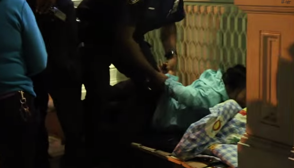 Kvinna brottas ned av polisen vid kön.